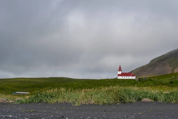 ヴィック アイスランドにある草の根の崖の上の丘の上にあるヴィク ミュルダル教会の風景 — ストック写真