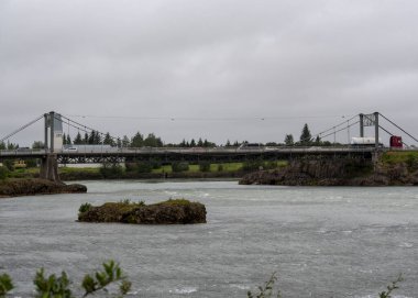 Selfoss 'ta bulutlu bir günde Olfusa nehri ve köprüsünün manzarası