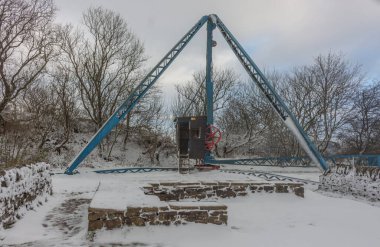 Tegg 'in Burun Parkı, Macclesfield, Cheshire, İngiltere' de kar içinde tarihi madencilik ekipmanları..