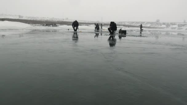 Menschen Fischer gehen auf den Wettbewerb auf dem Eis im Winter sitzen — Stockvideo
