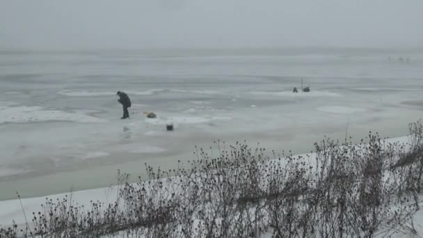 Mensen vissers gaan zitten op de competitie op het ijs in de winter — Stockvideo