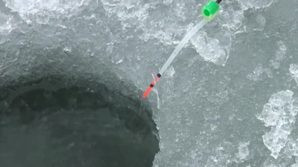 Agujero de hielo para la pesca en el hielo del río en invierno — Vídeos de Stock