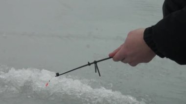 Buzdaki delik yakınlarında kışın nehrinde balık oltası