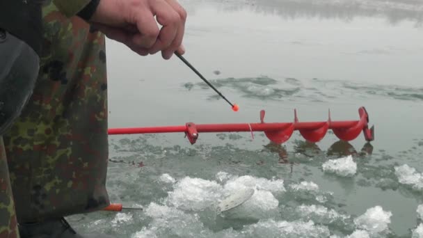 Angelrute im Winter auf dem Eis in der Nähe des Lochs — Stockvideo