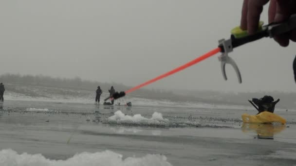 Canna da pesca sul fiume in inverno sul ghiaccio vicino al buco — Video Stock