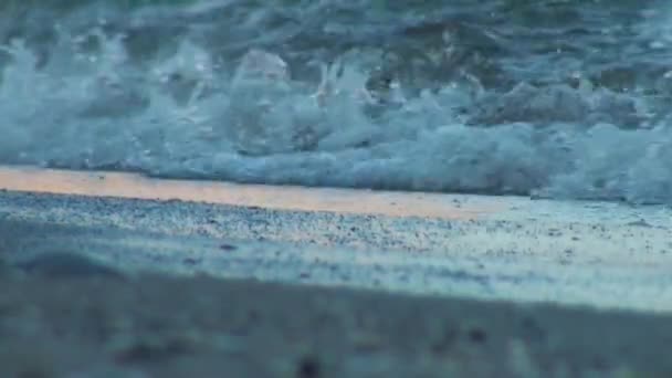 Água do mar atingindo a costa e regando a areia — Vídeo de Stock