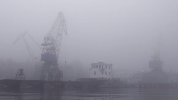 Kranen in de haven aan de rivier in het najaar van mist — Stockvideo