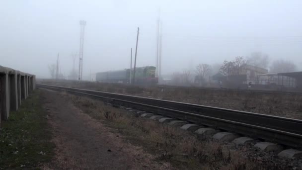 Tren funciona sobre raíles en la niebla otoño — Vídeo de stock