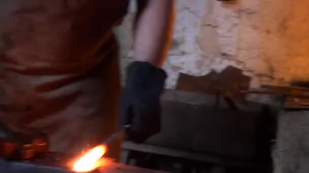 Blacksmith is hammering red-hot piece of iron — Stock Video