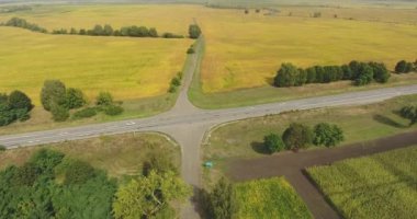 Tarımsal tarlalar arasında karayolu ve toprak yol kavşağı. Havadan görünüm doğası