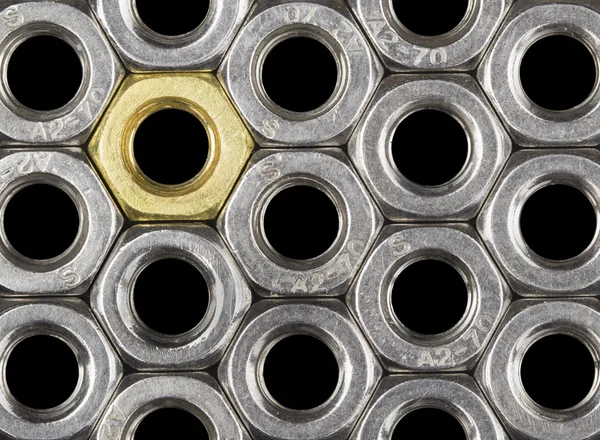 Golden screw nut in steel nuts — Stock Photo, Image