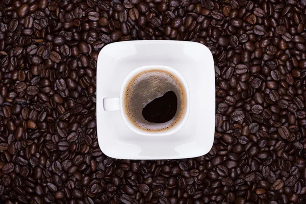 Taza de café con platillo en granos de café — Foto de Stock