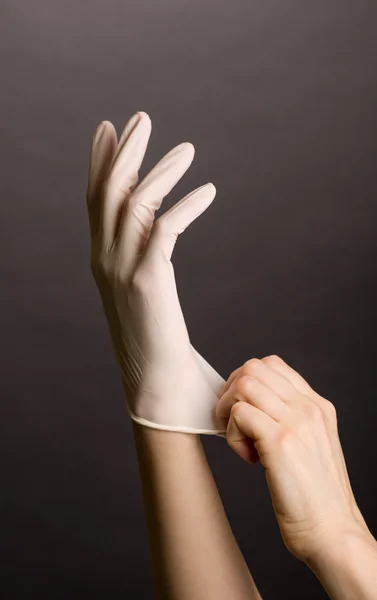 Female hands putting on latex gloves — Stock Photo, Image