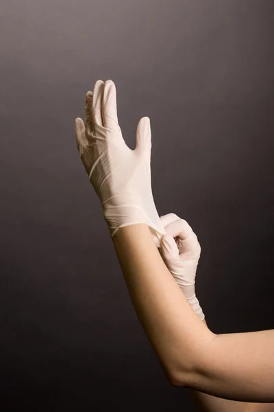 Female hands putting on latex gloves — Stock Photo, Image