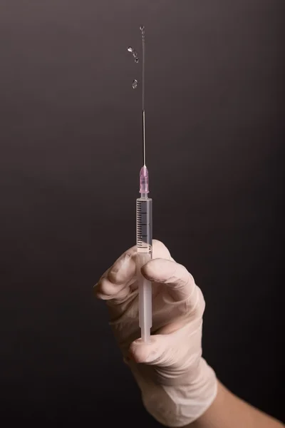 Female hand in latex glove with syringe — Stock Photo, Image