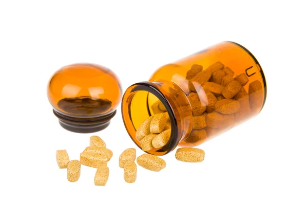 Pills spilling out of apothecary bottle — Stock Photo, Image