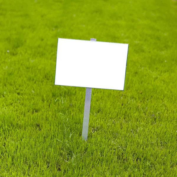 Podepsat na trávě whith izolovaný prostor pro titulek — Stock fotografie