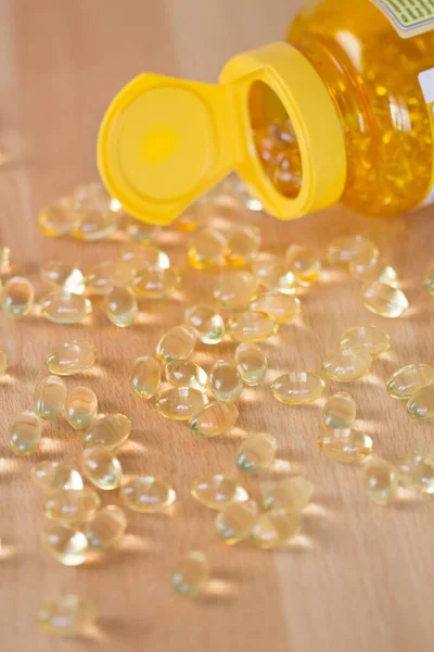 Fish oil omega pills spilled from a bottle — Stock Photo, Image