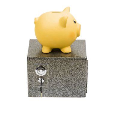 Sarı seramik domuz kumbarası bir kasanın üzerinde duruyor. Beyaz arkaplanda izole