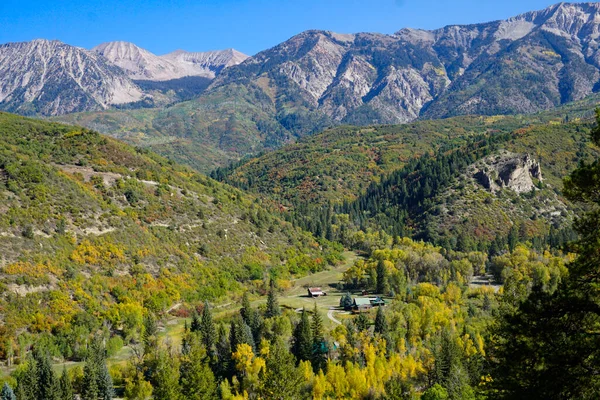 Ranch in a valley surrounded by mountains and fall color — Stock Photo, Image