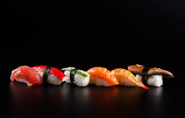 Japon deniz ürünleri suşisi, siyah arka planda.
