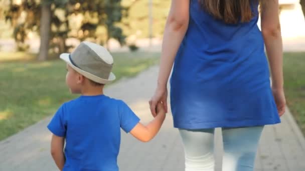 Een klein kind wees gaat door de hand met de weeshuis leraar, er is hoop en verdriet in zijn ogen, om te leven met een ouder, de droom van een verdrietig kind, verlangen naar een gelukkig gezin, kind en moeder — Stockvideo