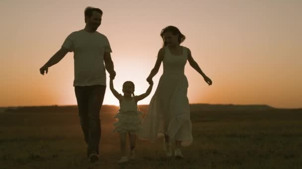 Happy mom dad and little kid run at sunset, travel on weekends, happy family, play fun, active family jogging, mother father are good parents for children, bring up a healthy baby, meet the dawn — Stock Video
