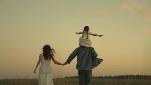 Happy family, cheerful father mother and child run sunset, little daughter with parents guardians in rays of light, kind dad and mom play in setting sun in an airplane flight, weekend travel together — Stock Video