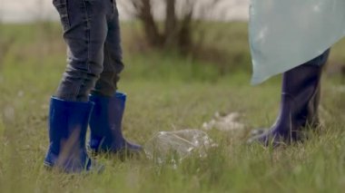 Gönüllü bir ekipteki küçük bir çocuk, yerdeki plastik çöpleri temizleyen bir çocuk, kirlilikten aile temizliği yapan bir kız, bebek dünyanın daha temiz, çevre, takım çalışması, mutlu bir aile olmasına yardım ediyor.