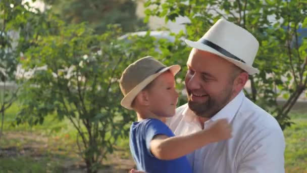 Een kleine jongen knuffelt zijn geliefde vader, vader is in de armen van zijn zoon, gelukkig gezinsleven, vaders dag, het opvoeden van een kind in het gezin, het leven van een kind met een oudere ouder, het opvoeden van baby als man, vrolijke jeugd — Stockvideo