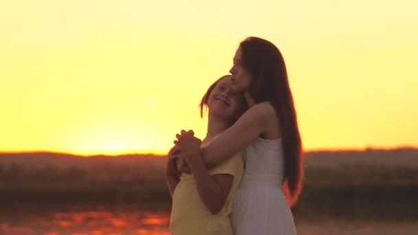 Moeder knuffelt en betreurt haar dochter tegen de achtergrond van de zonsondergang hemel, liefde kinderen, moeilijke leeftijd van tiener, zorg voor kinderen geestelijke gezondheid, wees attent en vriendelijk, zorg en mededogen — Stockvideo