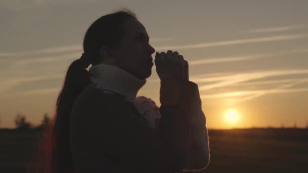 Meisje bidt bij zonsondergang aan de hemel, silhouet van een vrouw die om hulp vraagt, gebed in de zon leest, als gelovige leeft, Ramadan bij zonsopgang, zonden kwijtraakt, mediteert met handpalmen bij elkaar — Stockvideo
