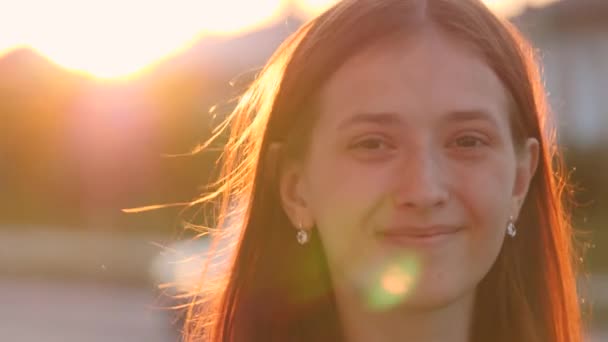 Giovane ragazza felice cammina lungo la strada sorridendo al tramonto in città, essere soddisfatti della vita, donne libere passeggiate nel parco, a piedi, al rallentatore, studente va a studiare all'alba presso l'istituto — Video Stock