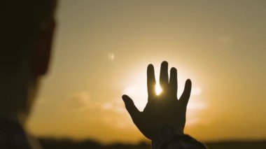 İnsan eli gün batımında gökyüzünde, mutluluk rüyası, güneş ışınlarında meditasyon, parlak turuncu ışık, tatilde seyahat, doğa ve rahatlığın ahengi, gün doğumuyla tanışma
