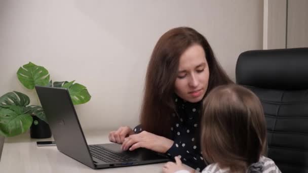 Mulher freelancer trabalhando em casa no computador, beijando uma criança pequena, profissão moderna on-line remotamente, encomendar comida na Internet, dama de negócios digitando no teclado remotamente — Vídeo de Stock