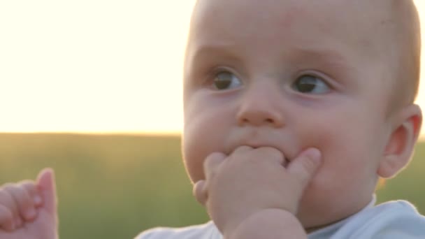 Niño pequeño chupa sus dedos en su mano, encías de niño pequeño son picazón, dientes de bebé son dentición, encías dolidas, niño primer año de vida, problema boca sana, lamer y babear puño, cara de primer plano — Vídeo de stock