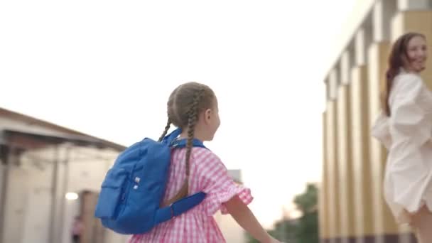 Девочка бежит вверх по лестнице в школу с рюкзаком на плечах, школьная сумка на первоклассник, счастливый ребенок спешит на урок, дошкольное воспитание ребенка, учеба в учебных заведениях — стоковое видео