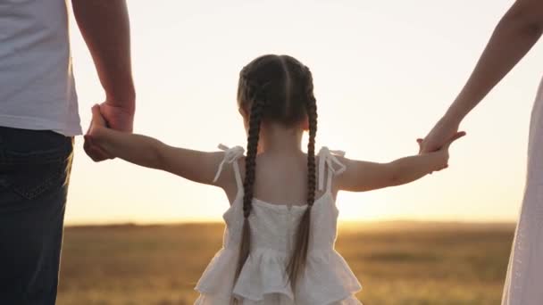 Criança segura seu pai e mãe à mão ao pôr do sol, família feliz, divirta-se e brinque com os pais no parque, boa vida infantil com mãe e pai gentis, sonho de infância de fantasia, bebê ao ar livre da natureza — Vídeo de Stock