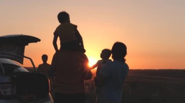 Mutlu aile gün batımında arabayla seyahat, anne baba ve çocuk arabayla turist gezisi, genç çiftin aile arabası, çocukluk hayali, baba omuzlarındaki küçük çocuk uçmayı hayal ediyor, çocuk pikniği.