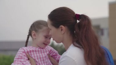 Anne küçük kızı sakinleştirir ve kucaklar, üzgün çocuk gözlerinden yaşlar akıtır, çocukların morali bozulur, çocuk stresli duygu, gözyaşları içinde çocukluk, ebeveynler ile bebek kaprisli davranışlar, kızlarının öfkesi