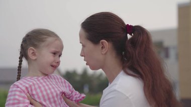 Anne küçük kızı sakinleştirir ve kucaklar, üzgün çocuk gözlerinden yaşlar akıtır, çocukların morali bozulur, çocuk stresli duygu, gözyaşları içinde çocukluk, ebeveynler ile bebek kaprisli davranışlar, kızlarının öfkesi