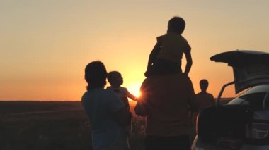 Mutlu aile gün batımında arabayla seyahat, anne baba ve çocuk arabayla turist gezisi, genç çiftin aile arabası, çocukluk hayali, baba omuzlarındaki küçük çocuk uçmayı hayal ediyor, çocuk pikniği.