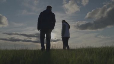 Gün batımında tarlada çiftçi silueti el ele verdi, tarım uzmanlarını birleştirdi, kırsalda yaşadı, ekme ve hasat mevsiminde tarlada çalıştı, takım çalışması yaptı.