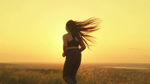 Chica corriendo al atardecer cielo, activa estilo de vida rayos sol, cardio entrenamiento naturaleza, corriendo hombre luz brillante, monitorear la salud y la forma del cuerpo, activar el metabolismo del cuerpo con ejercicios de ejercicio físico —  Fotos de Stock