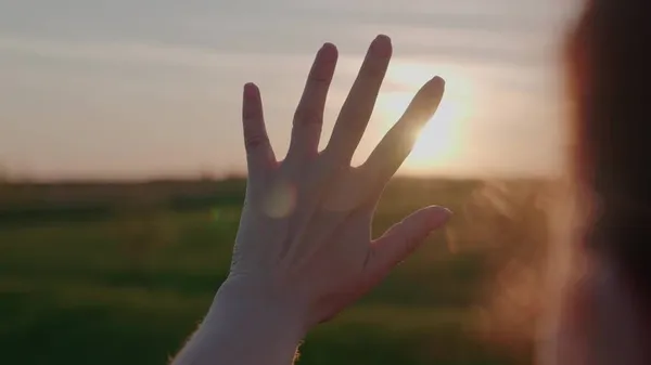 Deslumbramiento del sol a través de los dedos de las niñas, sueño de la mujer de la libertad, un viaje de los hombres al atardecer, la luz brillante del sol en su mano, hermoso resplandor de color del amanecer, orando sin recibir energía —  Fotos de Stock