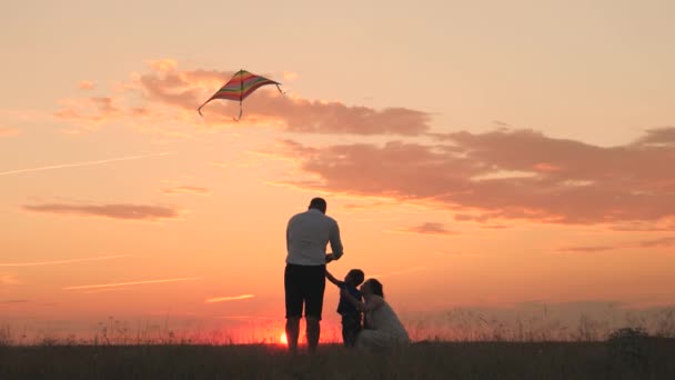 Père mère et petit enfant lancent cerf-volant volant haut dans le ciel du coucher du soleil, famille heureuse, vol de rêve d'enfance, enfant avec les parents voyage au soleil, maman papa et beby se reposer le week-end en plein air nature — Video