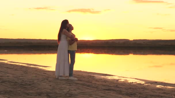 Madre abbraccia e rimpiange la figlia sullo sfondo del cielo al tramonto, ama i bambini, età difficile dell'adolescente, prendersi cura della salute mentale dei bambini, essere attenti e gentili, cura e compassione — Video Stock