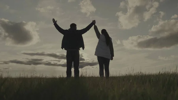 日没時の男と女のシルエット太陽の下でパートナーの手を握るチームワーク企業の幸せな農業グループ成功したビジネスチーム成功した人々の信頼団結の喜び — ストック写真