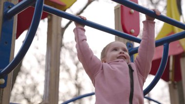 Gülümseyen küçük çocuk merdivenlerden çıkıyor, baba çocuğun oyun alanına tırmanmasına yardım ediyor, eğlenceli bir çocukluk için eğlence kompleksi, mutlu aile günü, baba günü, hafta sonu bebekle aktif istirahatte, enerjik anaokulu oyunu