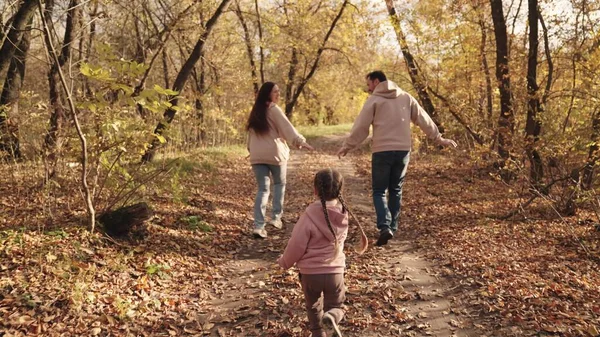 Küçük çocuk anne ve babasına yetişiyor, mutlu aile, aktif çocuklar, sonbaharda açık hava oyunları, neşeli çocuk anne ve babasıyla gülüyor, birlikte tatile çıkıyor, çocuklar eğlenceli rüyalar görüyor.